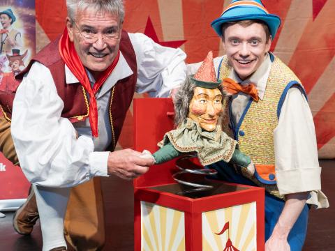 An image of Geppetto and Pinocchio with a wooden jack in a box